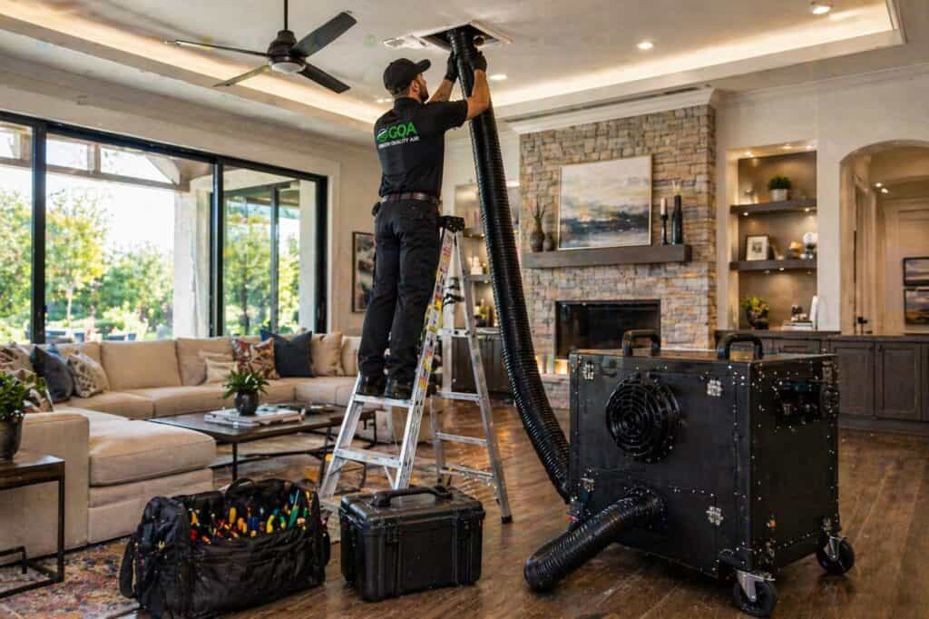 Professional air duct cleaning technician working in a Texas home