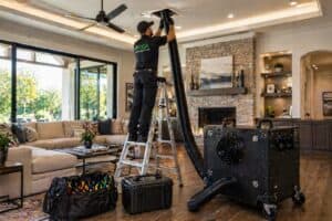 Professional air duct cleaning technician working in a Texas home